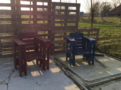 a group of chairs sitting next to a fence at Sitting at the Bay in Zuiderwoude