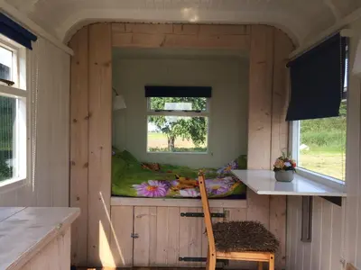 a small room with a bed in a tiny house at Sitting at the Bay in Zuiderwoude