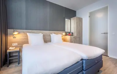 a bedroom with a large bed and a desk at Joy Hotel in Amsterdam