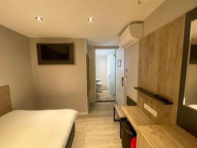 a small room with a bed and a bathroom at Joy Hotel in Amsterdam