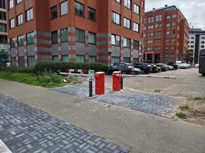 a parking lot with red barriers in front of a building at Joy Hotel in Amsterdam