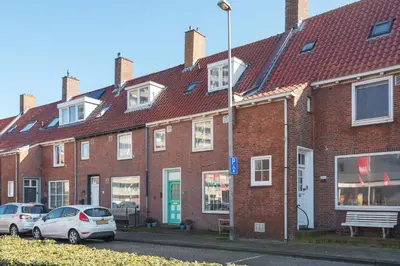 a row of brick houses with cars parked in front at B&B Little Miss Sunshine in Zandvoort