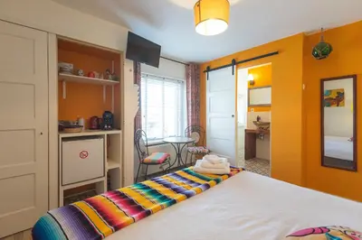 a bedroom with a bed and a table in a room at B&B Little Miss Sunshine in Zandvoort