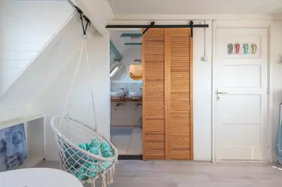 a room with a door and a swing at B&B Little Miss Sunshine in Zandvoort