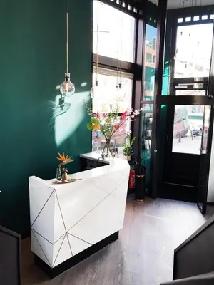 a white cabinet in a room with a green wall at Linden Hotel in Amsterdam