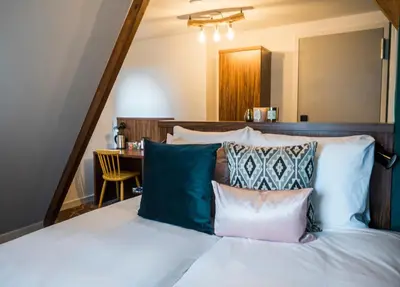 a bedroom with a bed with pillows and a table at Linden Hotel in Amsterdam