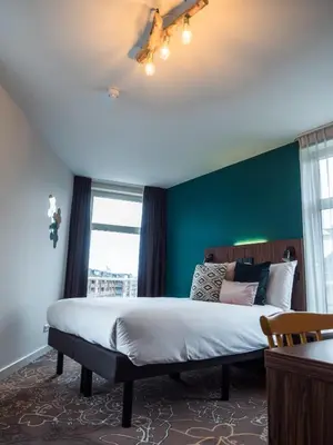 a bedroom with a bed and a green wall at Linden Hotel in Amsterdam