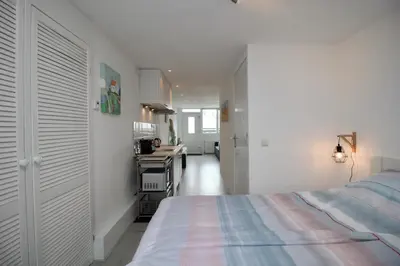 a bedroom with a bed and a desk in it at Casa Belle Dune in Zandvoort
