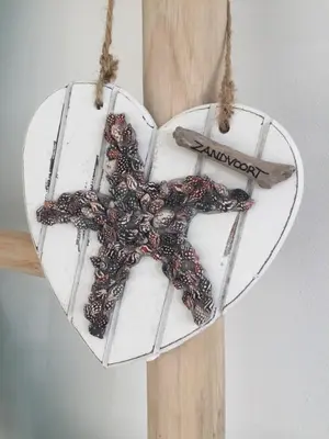 a white heart hanging on a wooden pole at Casa Belle Dune in Zandvoort