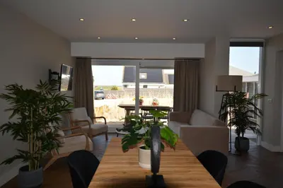 a living room with a table and some plants at Strandstudio's Camperduin in Schoorl