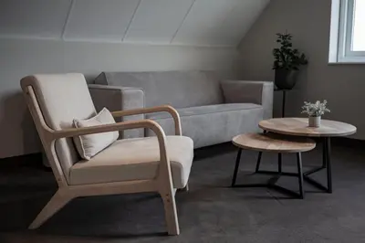 a living room with a couch and a chair and a table at Strandstudio's Camperduin in Schoorl
