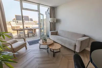 a living room with a couch and a table at Strandstudio's Camperduin in Schoorl