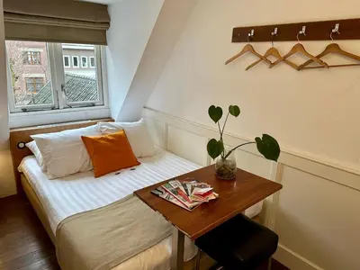 a small room with a bed and a table at Long John's Pub & Hotel in Amersfoort