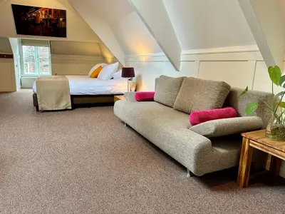 a living room with a couch and a bed at Long John's Pub & Hotel in Amersfoort