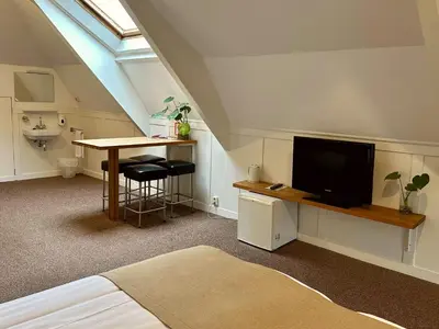 a room with a bed and a tv and a table at Long John's Pub & Hotel in Amersfoort