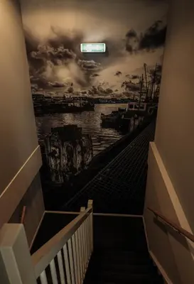 a staircase with a mural of a harbor at Hotel Royal in IJmuiden