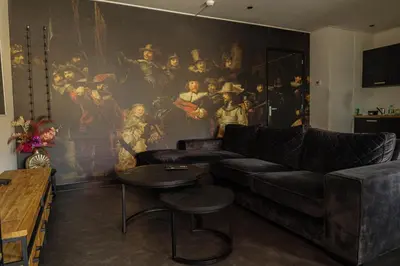 a living room with a couch and a painting on the wall at Hotel Royal in IJmuiden