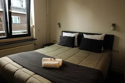 a bedroom with a large bed with a basket on it at Hotel Royal in IJmuiden