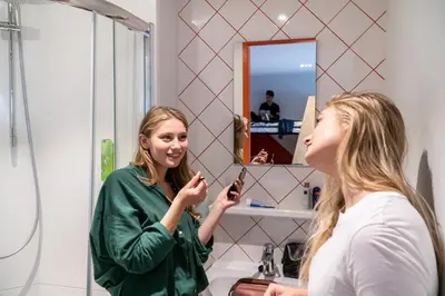 a woman looking at her reflection in a mirror at Via Amsterdam in Amsterdam