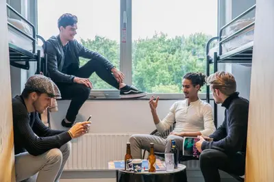 four men sitting on a train looking at their cell phones at Via Amsterdam in Amsterdam