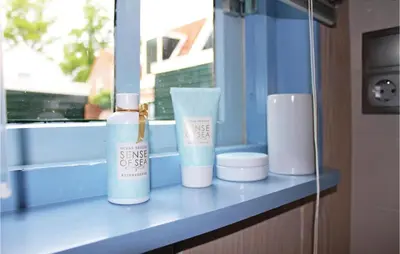 a shelf with two bottles of soap and a window at Het Edamse Vissershuisje in Edam