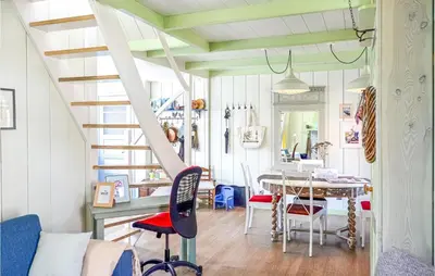 a room with a staircase and a table and chairs at Het Edamse Vissershuisje in Edam