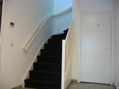 a staircase with black treads and a white wall at Guest House Amsterdam in Amsterdam