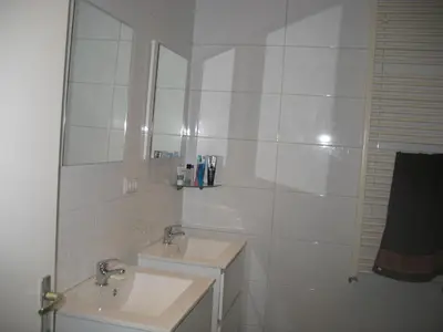 a white bathroom with two sinks and a mirror at Guest House Amsterdam in Amsterdam