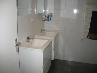 a white bathroom with two sinks and a mirror at Guest House Amsterdam in Amsterdam