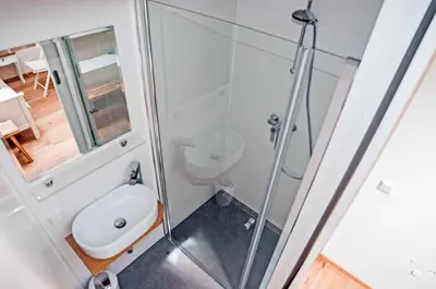 a bathroom with a toilet and a glass shower at Cozy Bungalow for 2 Zandvoort in Zandvoort