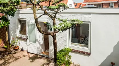 a house with a tree in front of a window at Cozy Bungalow for 2 Zandvoort in Zandvoort