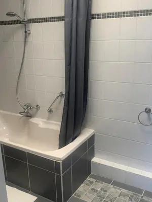 a bathroom with a shower with a tub and a shower curtain at Hotel Flevo in Zeewolde
