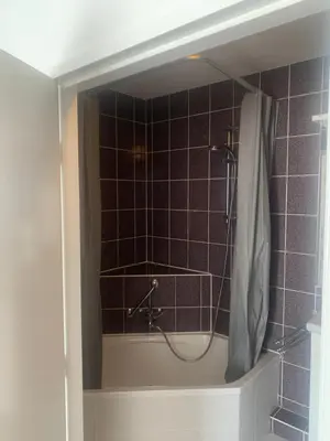 a bathroom with a shower with a shower curtain at Hotel Flevo in Zeewolde