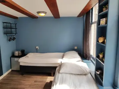 a room with a bed in a blue wall at Urban Vibes Guesthouse in Amsterdam