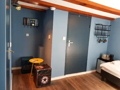 a bedroom with blue walls and a sliding door at Urban Vibes Guesthouse in Amsterdam