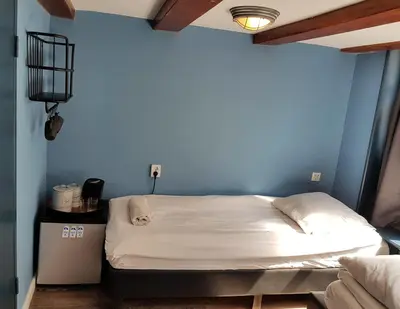 a bed in a room with a blue wall at Urban Vibes Guesthouse in Amsterdam