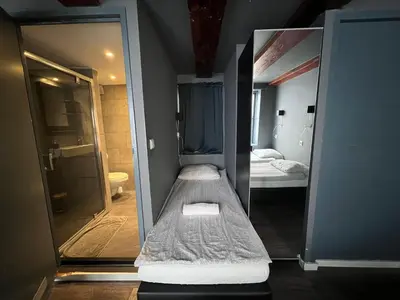 a small room with a bed and a mirror at 7B&B in Amsterdam
