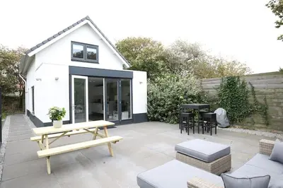 a backyard patio with a table and chairs at Salt Life Beachhouse in Noordwijk aan Zee