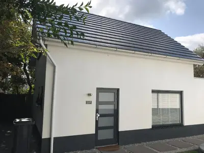 a white building with a black door at Salt Life Beachhouse in Noordwijk aan Zee