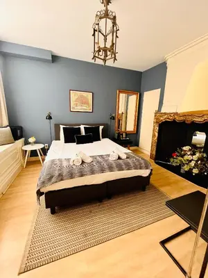 a bedroom with a large bed and a fireplace at Patrick's Place in Amsterdam