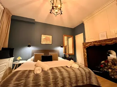 a bedroom with a large bed and a chandelier at Patrick's Place in Amsterdam