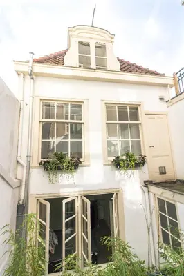 a white house with windows and potted plants at Patrick's Place in Amsterdam