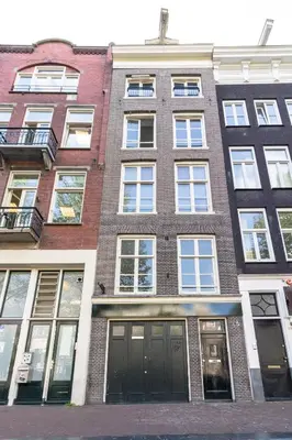 a brick building with lots of windows on a street at Patrick's Place in Amsterdam