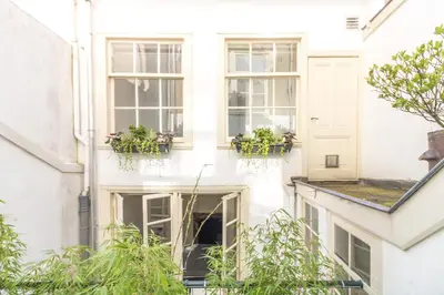 a white house with windows and potted plants at Patrick's Place in Amsterdam