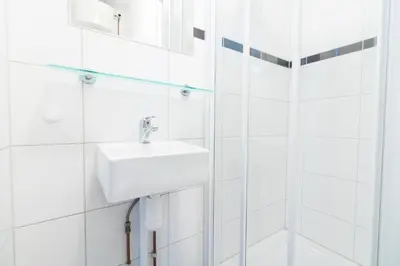 a white bathroom with a sink and a mirror at Patrick's Place in Amsterdam