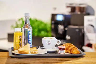 a tray with a plate of bread and a cup of coffee at Amrâth Apart-Hotel Schiphol Badhoevedorp in Badhoevedorp