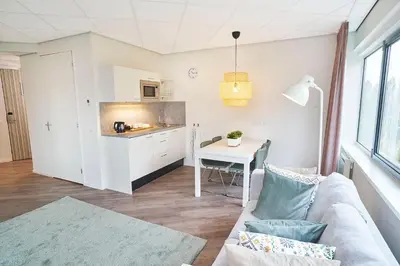 a living room with a couch and a table at Amrâth Apart-Hotel Schiphol Badhoevedorp in Badhoevedorp