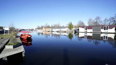 a red boat is docked next to a dock at Amrâth Apart-Hotel Schiphol Badhoevedorp in Badhoevedorp