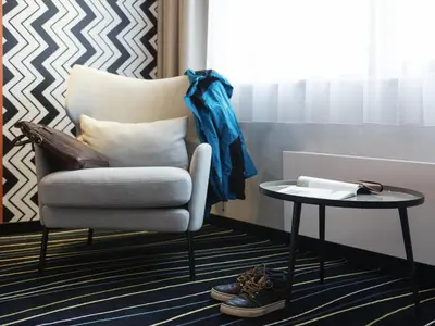 a chair and a side table next to a window at ibis Styles Haarlem City in Haarlem