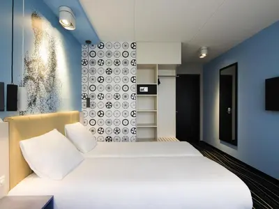 a bedroom with a white bed and blue walls at ibis Styles Haarlem City in Haarlem